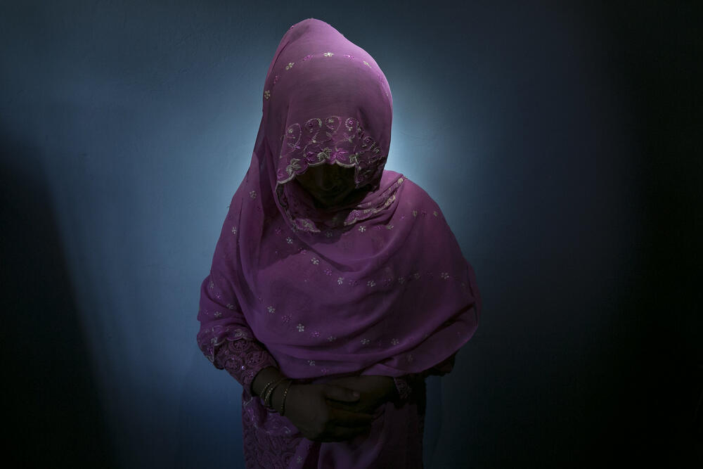 Woman wearing traditional clothes with a scarf covering her head and face