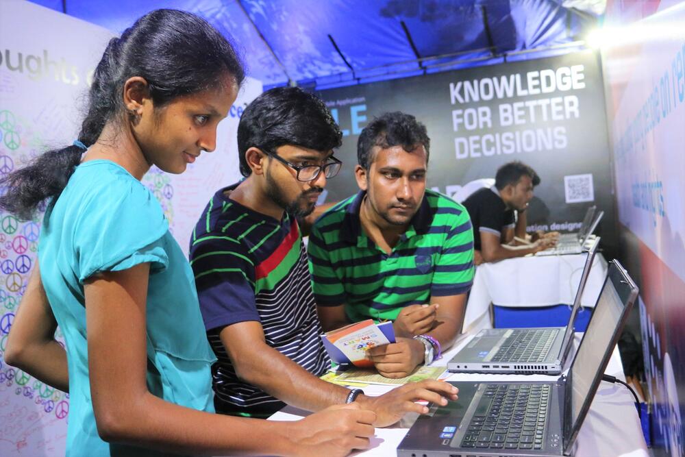 Young adults using a computer at a booth