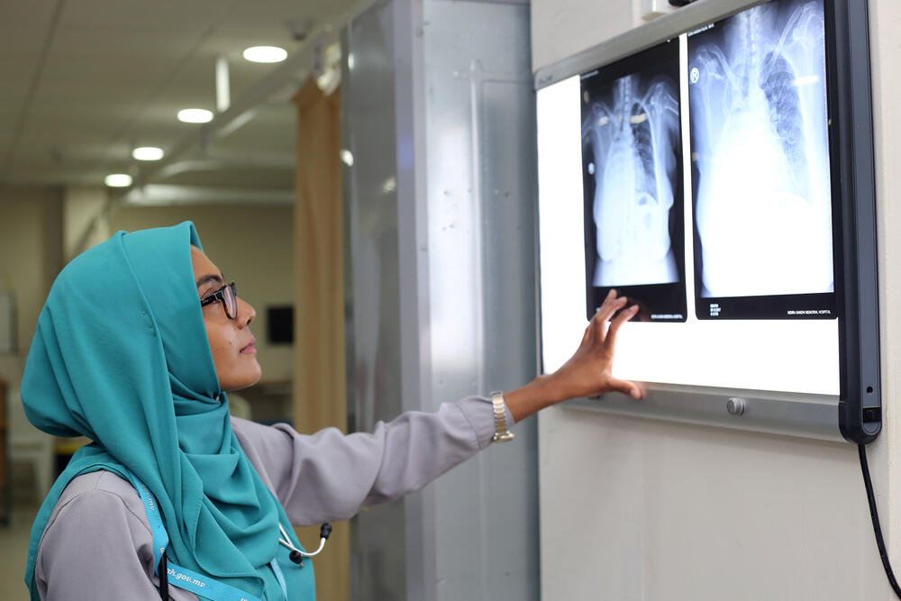 Photo of a female health professional examining an x-ray image 