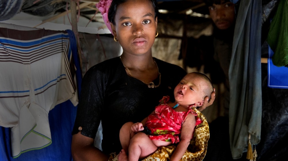 Mother holding her baby at home