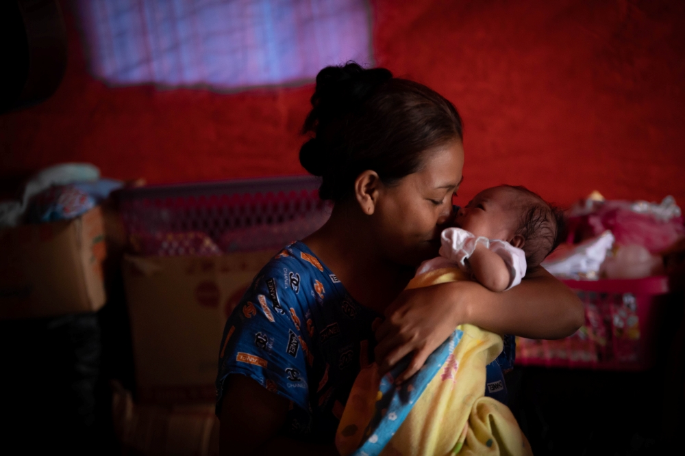 Mother holding and kissing her baby