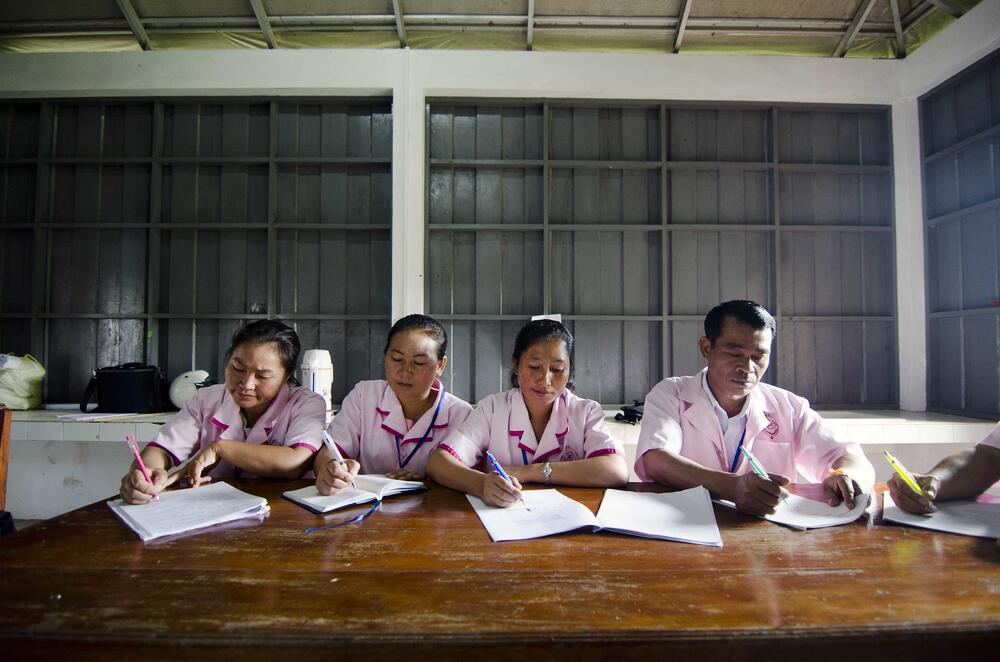 Midwives writing on paper sheets