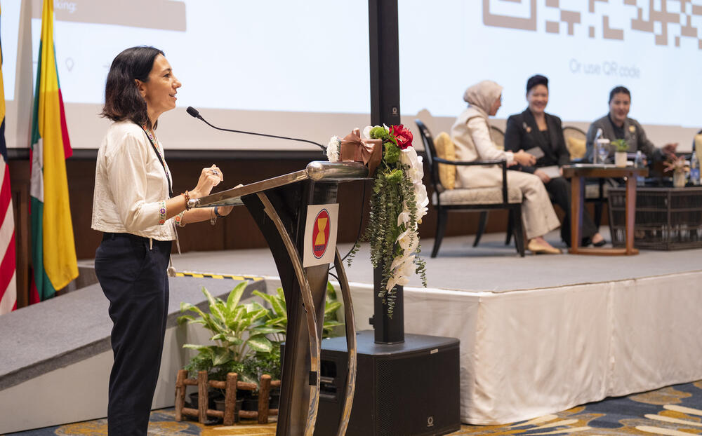 Woman speaking at the podium in a conference room