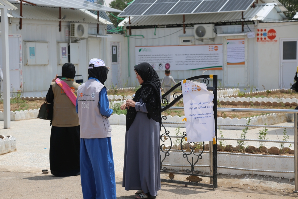 Young person and a pregnant woman at a refugee camp