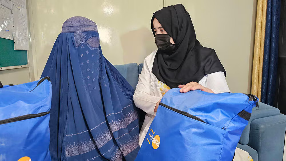 Zuleyha (left) receives a Dignity Kit from a health worker following a psychosocial counselling session.