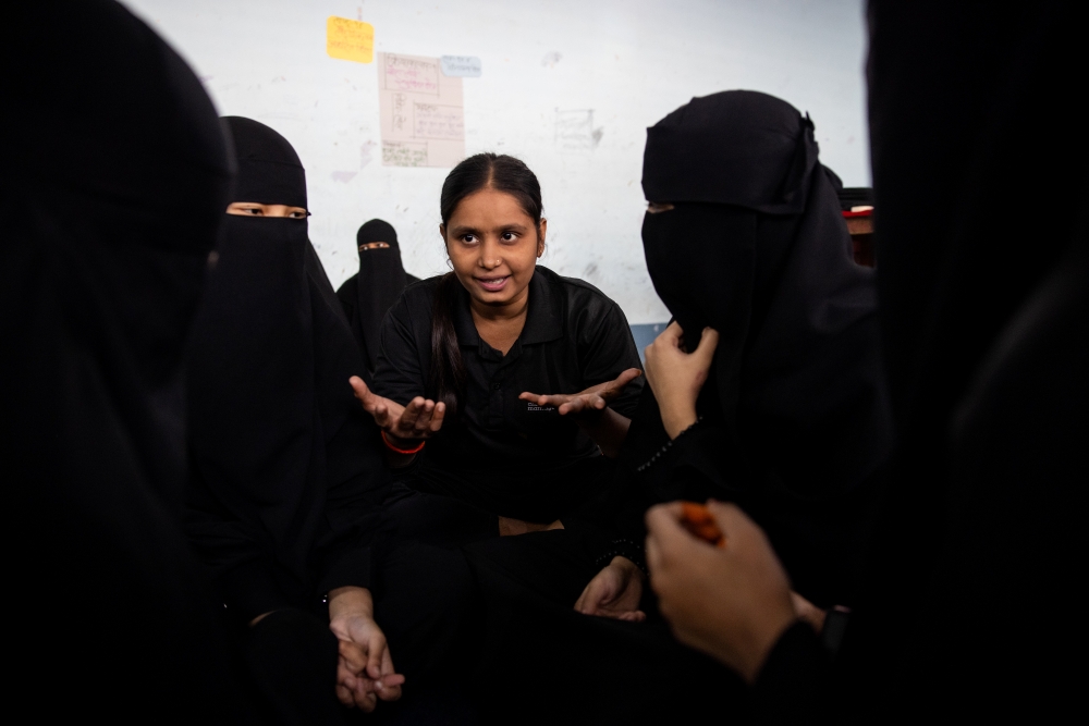Young woman speaking to other women in a circle