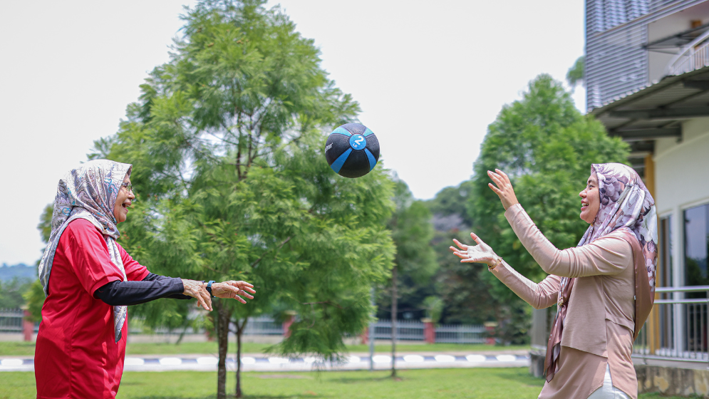 Old woman and a young girl playing a ball