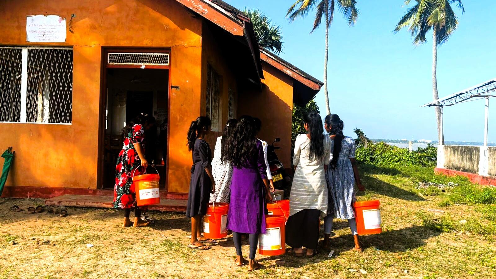 Women and girls carrying Dignity Kits provided by UNFPA