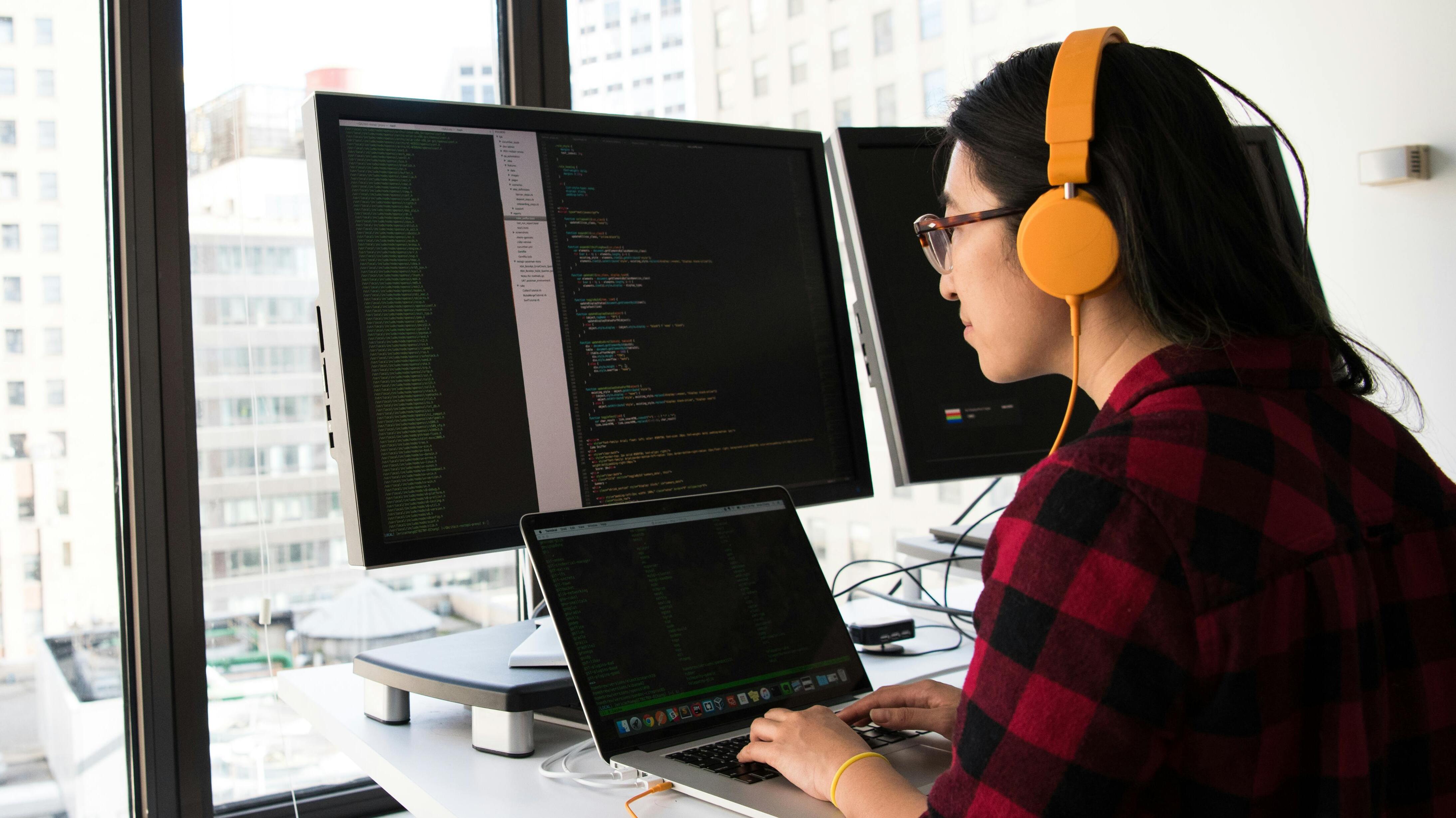 Asian woman working on a laptop writing programming codes