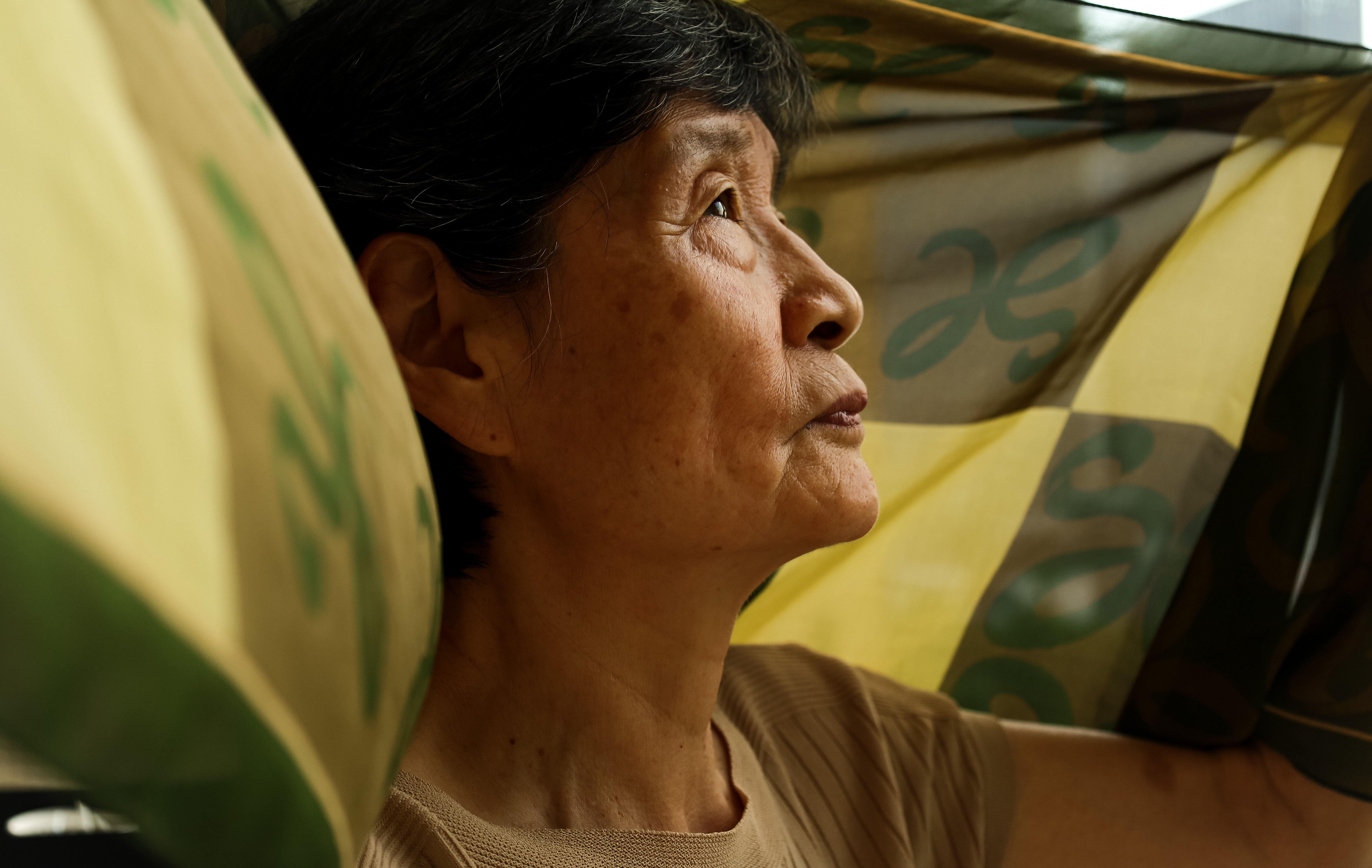 An older woman holding a scarf