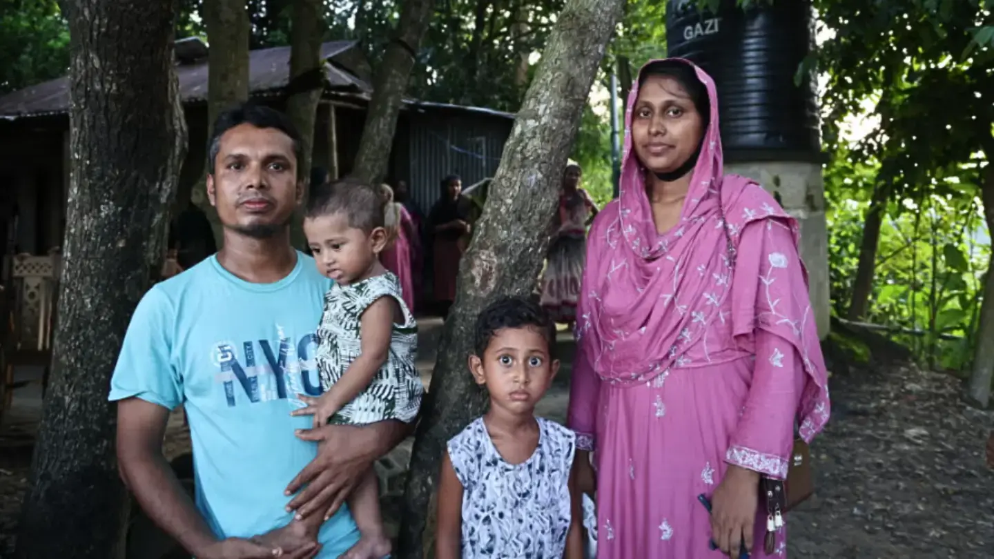 Anima Akhter, 24, stands with her husband Ruhul Amin, 30, and their two children outside their home in Bodipur village, Sunamganj. © UNFPA Bangladesh/Asma Akter